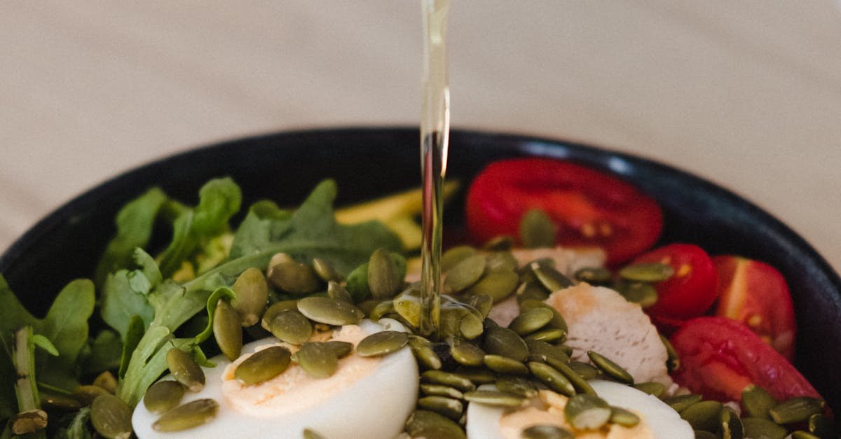 Delicious whole grain salad with fresh vegetables, pumpkin seeds, and olive oil pour.